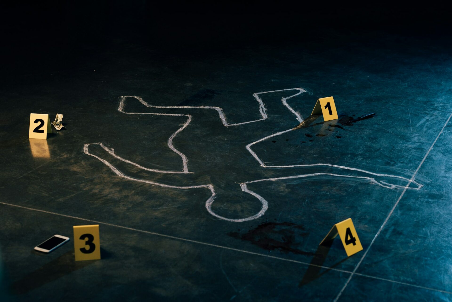 chalk outline and evidence markers at crime scene