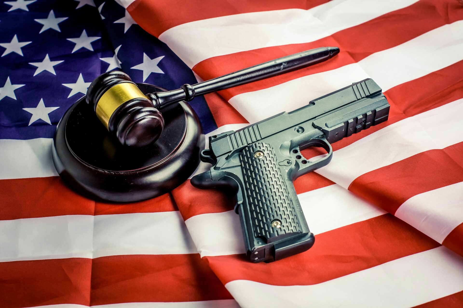 Wooden judge gavel and black color gun over USA flag. Subscribe my channel: https://www.youtube.com/@earthzoom | Donation: https://fantalks.io/r/bermixstudio - any amount appreciated 🤘 Thanks friend!