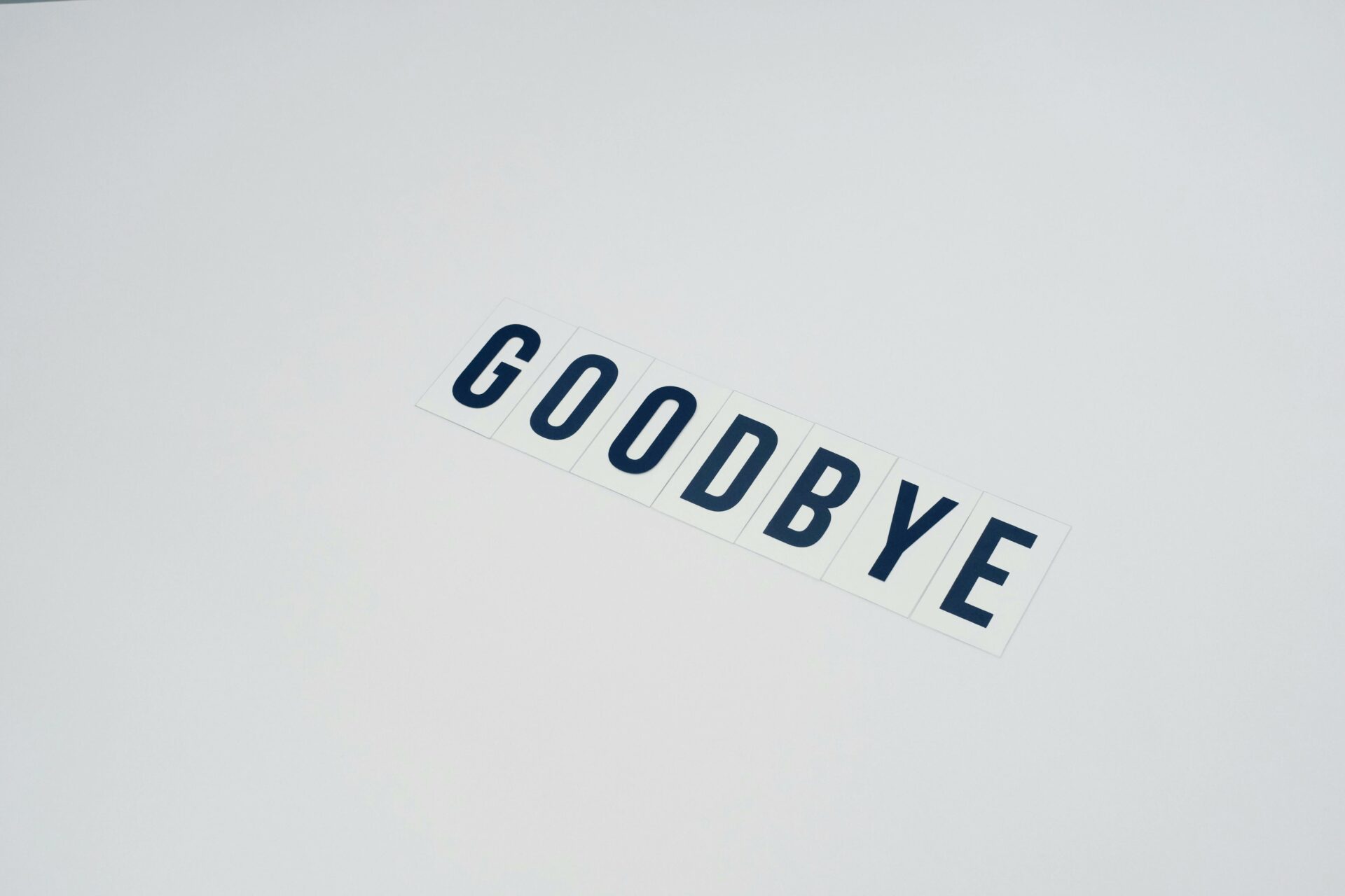 Word goodbye on white surface